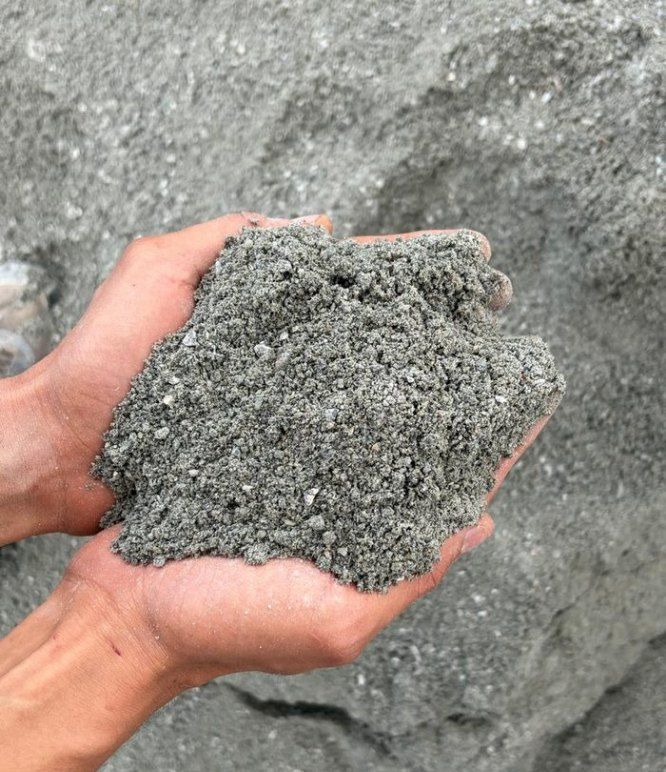 Pó de pedra nas mãos, sobre pilha de pó de pedra